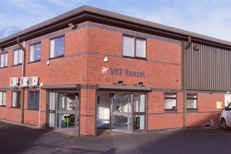 An image of the outside of VKF Renzel's headquarters which is a red brick building with the company logo on the side